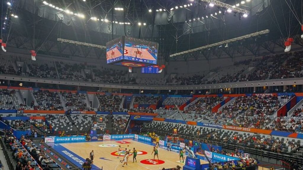 Pemain basket profesional sedang bertanding dalam pertandingan basket modern dengan strategi dan teknik terbaru.